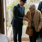 Transport personnes âgées longue distance : chauffeur aide une femme âgée à monter dans le véhicule